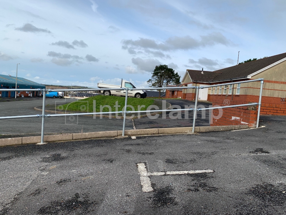 Guardrail constructed with Interclamp key clamp fittings and tube at an industrial car park, designed for optimal safety and stability.